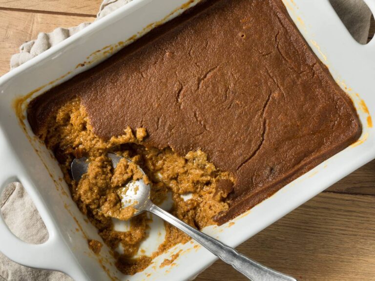 Białe prostokątne ceramiczne naczynie z budyniem z kaszy, polanym czekoladą. Ilustracja do artykułu "Doradzamy, jak zrobić zdrowy budyń z kaszy kukurydzianej dla całej rodziny"