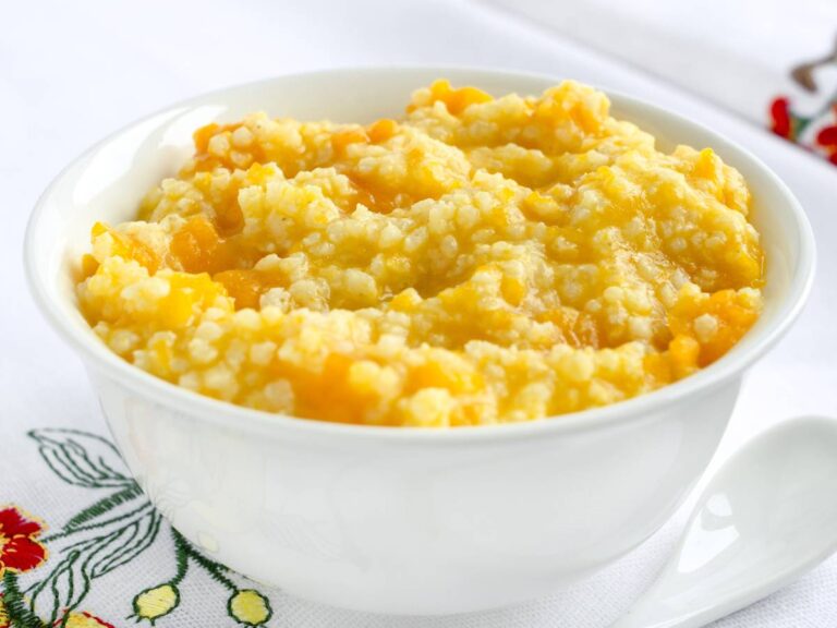 Miska ugotowanej kaszy jaglanej na szarobłękitnym tle. Ilustracja do artykułu "Odkryj 6 kreatywnych pomysłów na to, co zrobić z ugotowanej kaszy jaglanej i unikaj marnowania jedzenia"