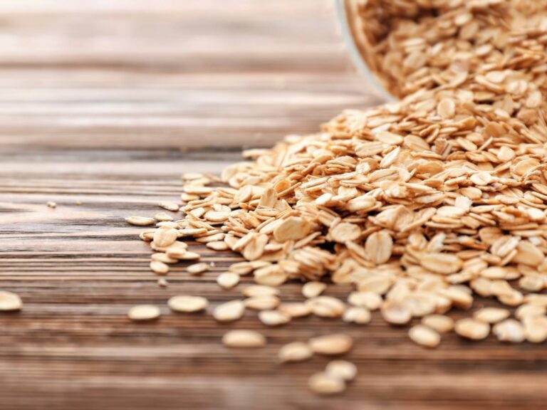 Suche płatki owsiane rozsypane na stole. Ilustracja do artykułu: "Odkrywamy, czy można jeść surowe płatki owsiane, jeśli masz wątpliwości"