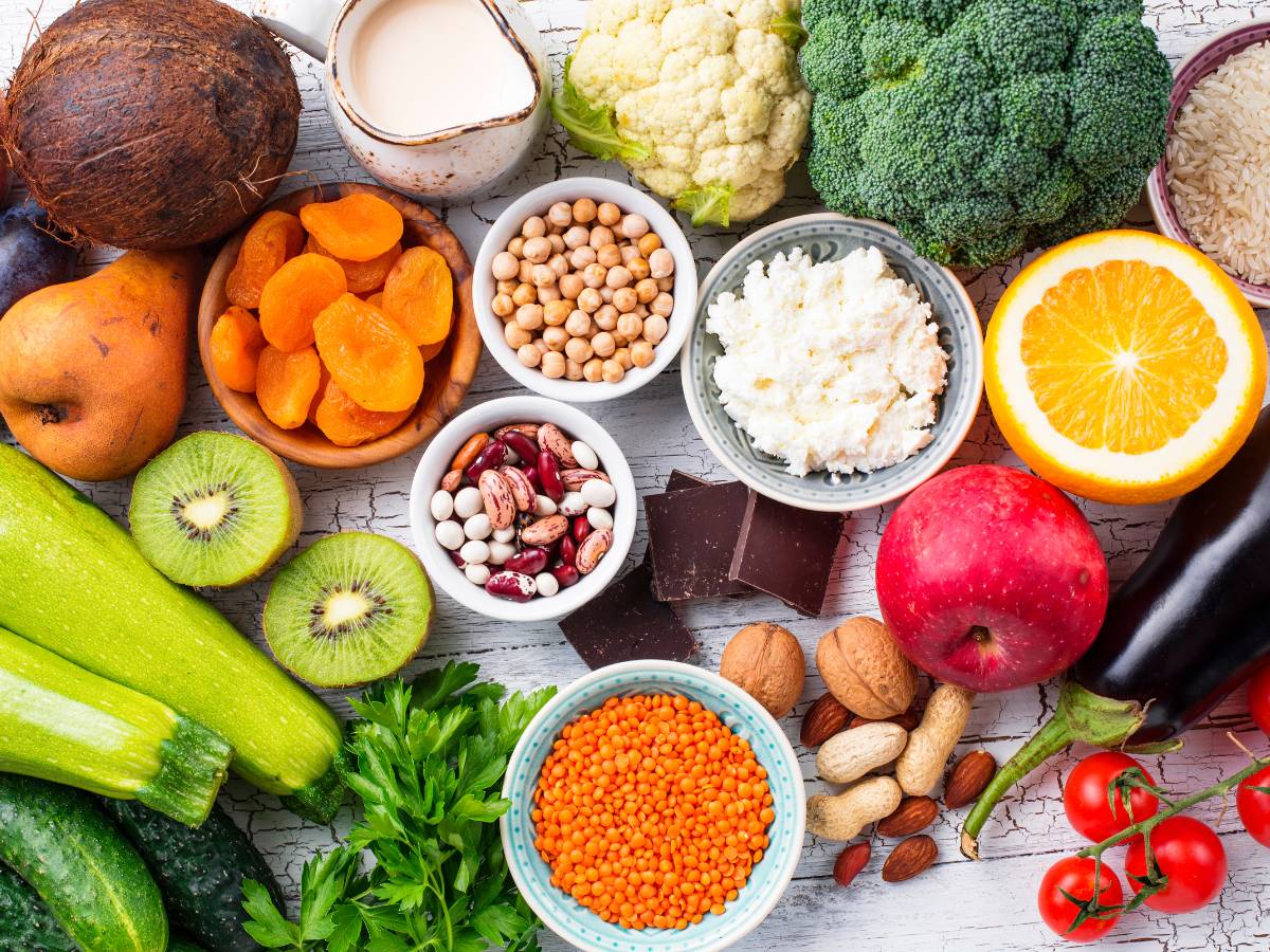 Różne produkty żywnościowe ułożone na stole i w miseczkach: kasze, warzywa, mięso, nabiał. Ilustracja do artykułu: "Poznaj indeks glikemiczny 8 rodzajów kasz, od najmniejszego do najwyższego"