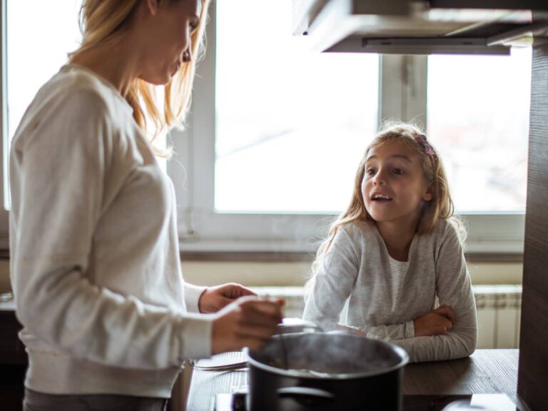 Dwie kobiety w kuchni, przy garnku, stojącym na kuchence. Ilustracja do artykułu: "Odkryj tajniki, jak gotować płatki owsiane, aby były idealnie miękkie i smaczne"