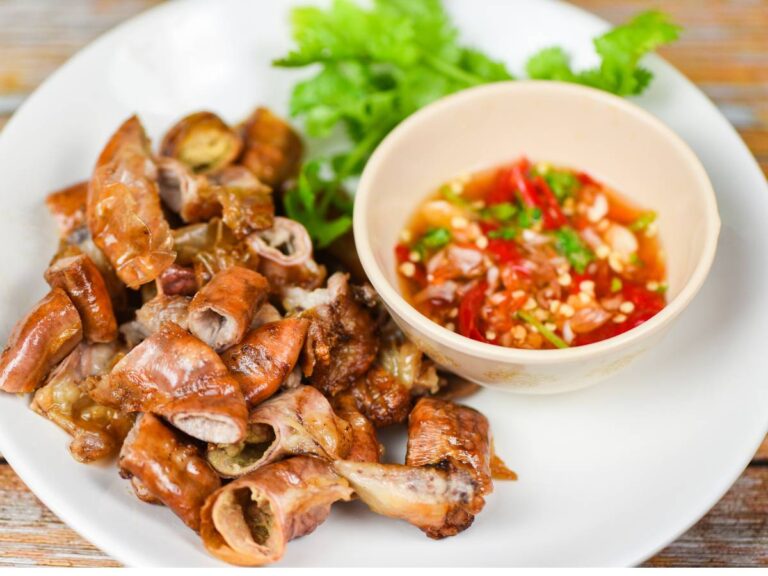 Duży talerz ze smakiowitym mięsem w kawałkach i na nim obok postawiona mała miseczka z kaszą jaglaną z warzywami. Ilustracja do artykułu: "Odkryj, dlaczego dietetycy polecają kaszę jaglaną na jelita"