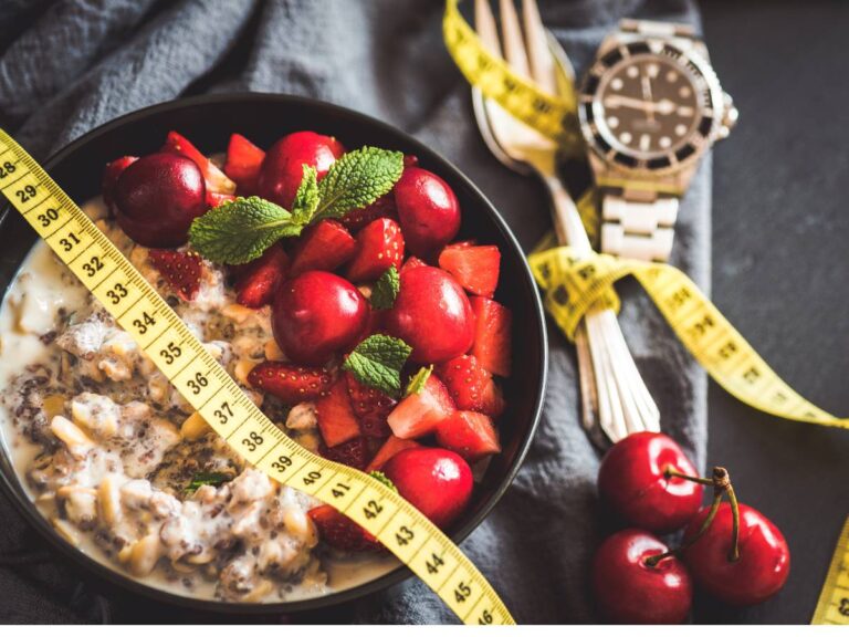 Miska z kaszą i warzywami pod centymetrem i obok sztućce, związane miarką krawiecką. Ilustracja do artykułu:"Odkryj prawdę, czy kasza kuskus idzie w parze z odchudzaniem"