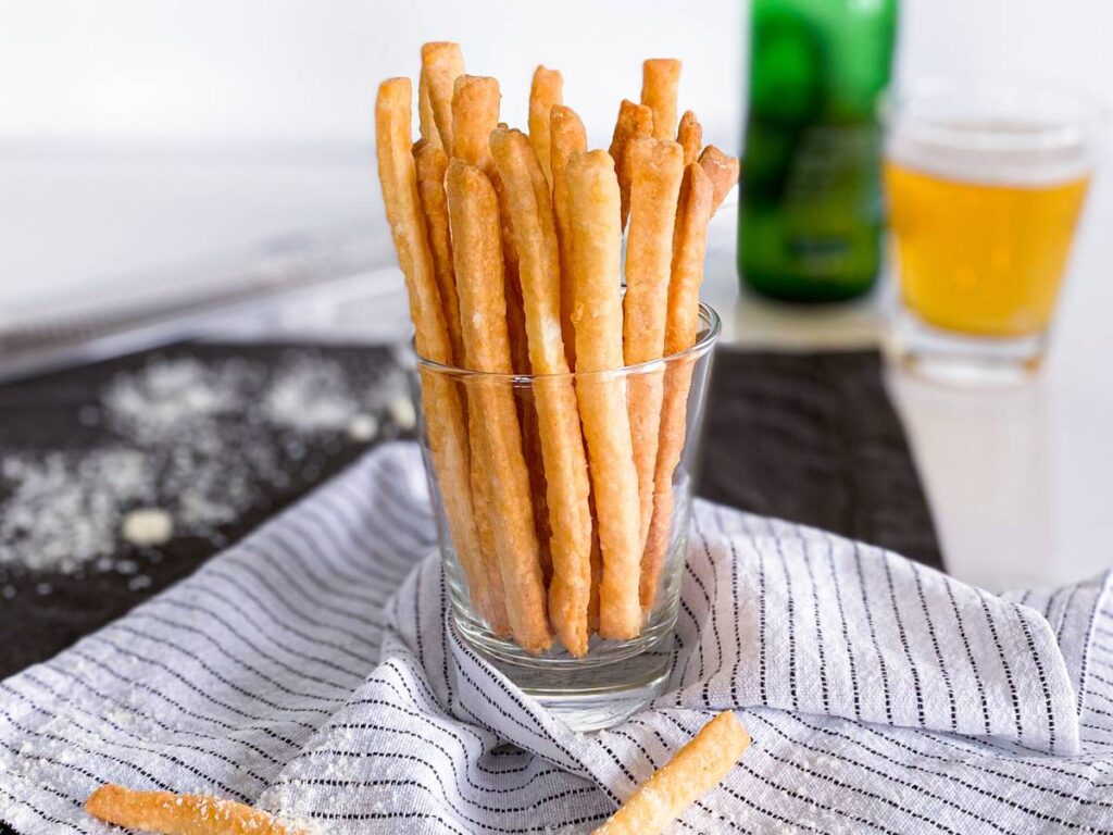 Pionowa aranżacja paluchów serowych w szklanym naczyniu