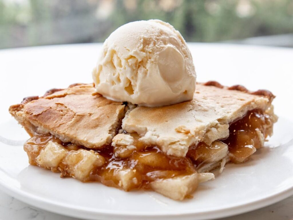 Elegancka propozycja podania szarlotki na spodzie orkiszowym z lodami