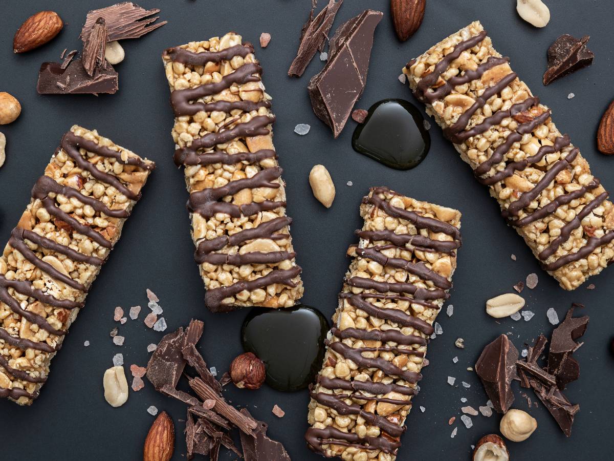 Domowe batony musli podane na drewnianej desce z filiżanką kawy