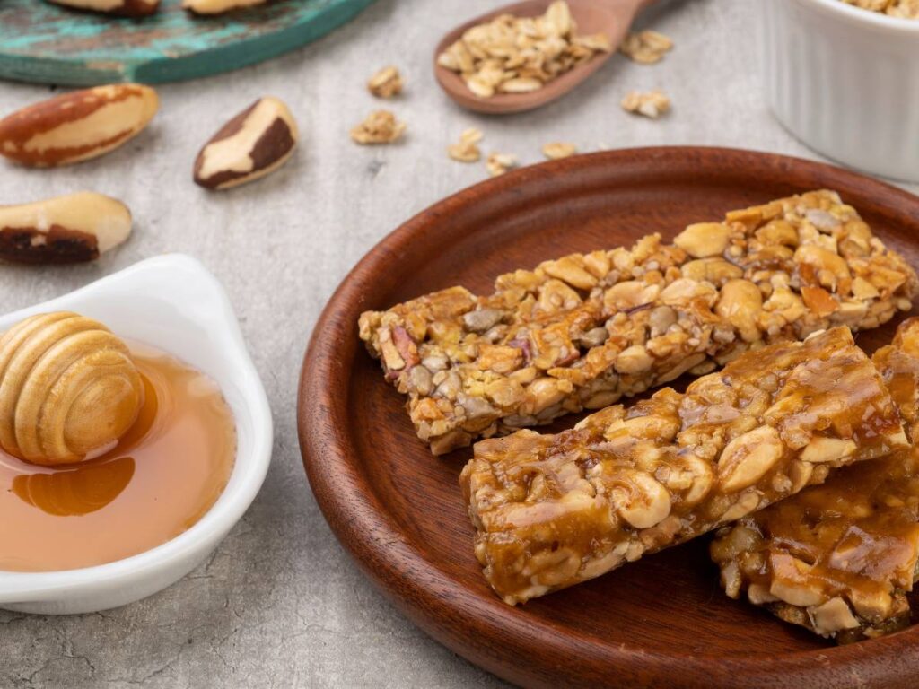 Batony musli na rustykalnym talerzu podane z miodem